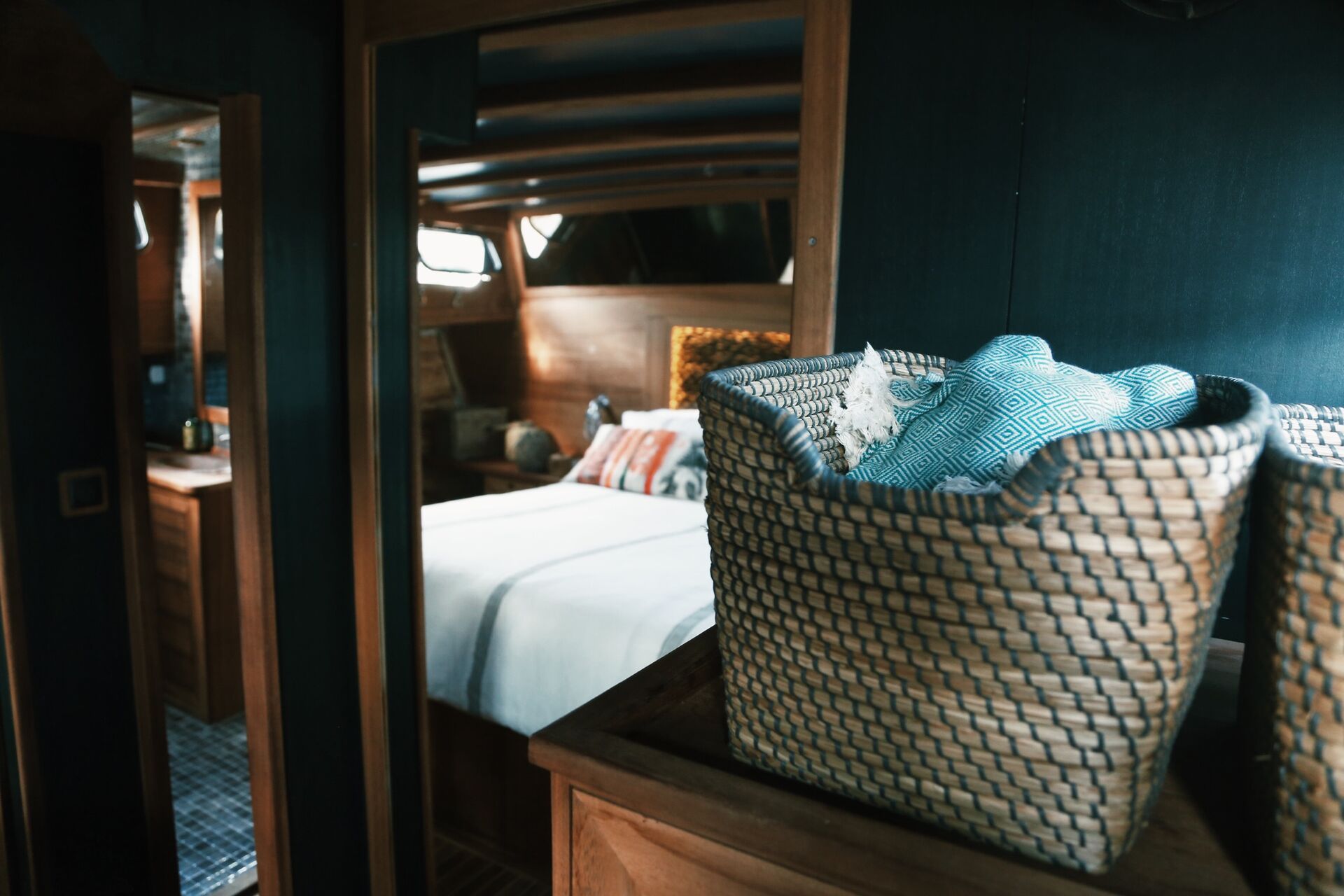 An aft cabin with a double bed, woven headboard and en-suite doorway