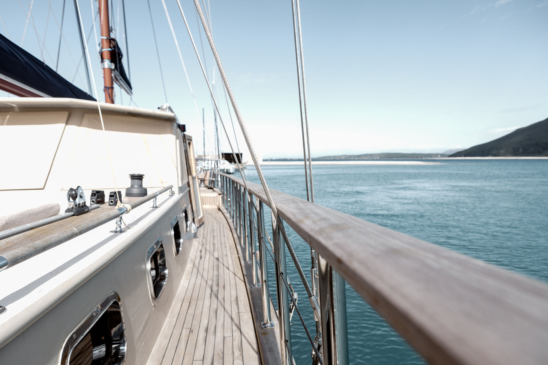 The teak side deck of Sea Moon with rigging and railings